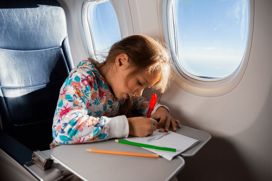 Child drawing while waiting for airplane snacks